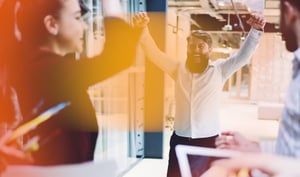 Team of sales people cheering after a client victory