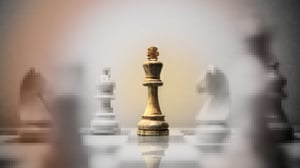 Chess board with all pieces but the King pixelated and gray